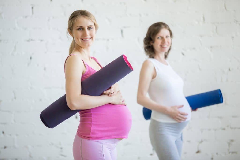 Two pregnant women with exercise mats